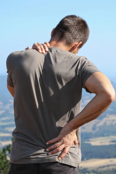 Man clutching his lower back in pain from a work injury