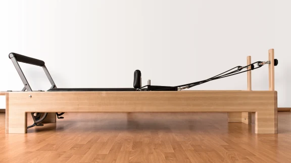 Physiotherapist guiding a mat-based Pilates exercise