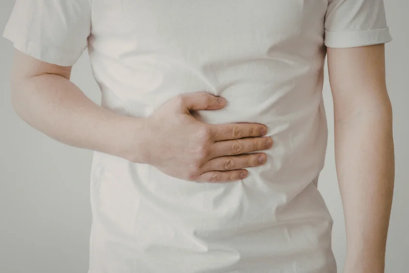 Close-up of a person holding their stomach in pain