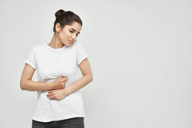 Woman clutching her stomach due to digestive discomfort