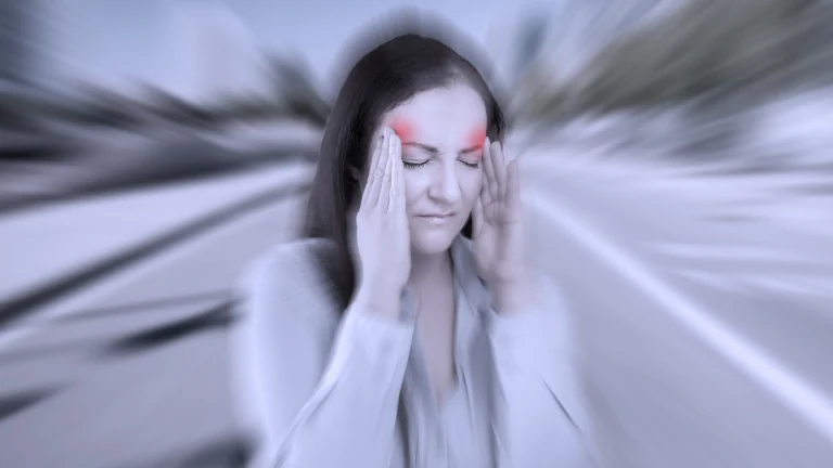 Woman holding her head in pain from a migraine