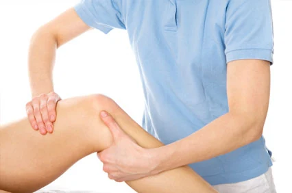 Physiotherapist treating a patient's calf for a work-related injury